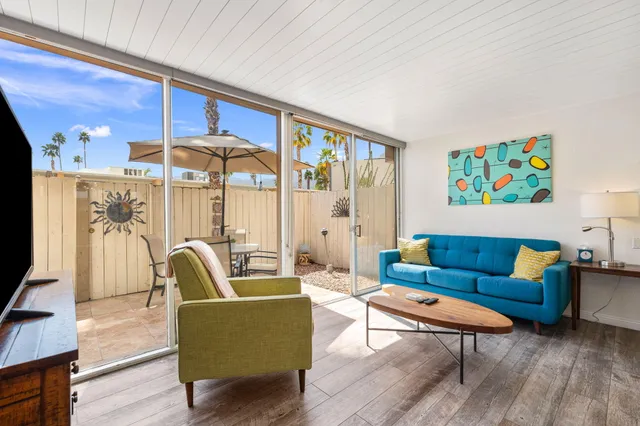 a living room with furniture a rug and a floor to ceiling window