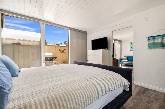 a bedroom with a large bed and a flat tv screen