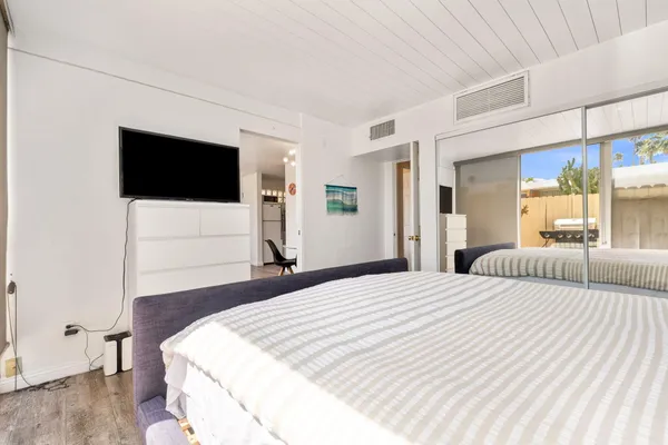 a bedroom with a bed and a flat screen tv