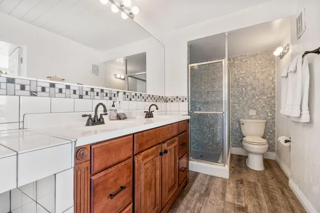 a bathroom with a sink a toilet and shower