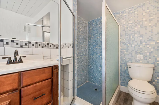 a bathroom with a granite countertop sink toilet and shower