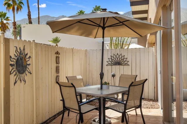 a view of a patio with furniture and umbrella