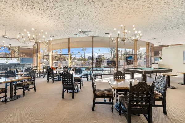 a dining hall with stainless steel appliances lots of white furniture