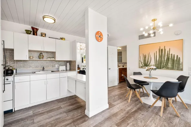 a kitchen with stainless steel appliances a dining table chairs and a refrigerator