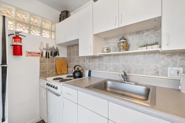 a kitchen with stainless steel appliances a sink a refrigerator and a cabinets
