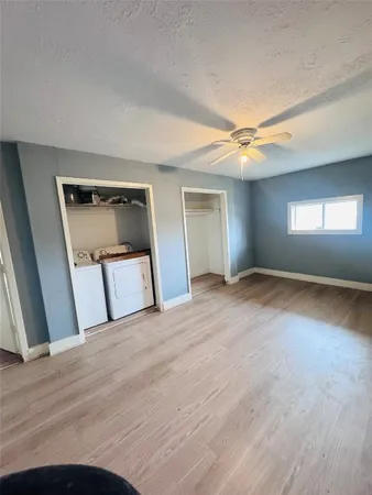a view of empty room with window and wooden floor