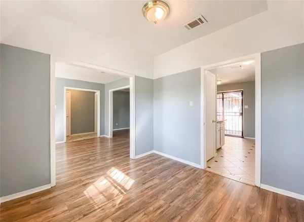 a view of a hallway with wooden floor and a bathroom