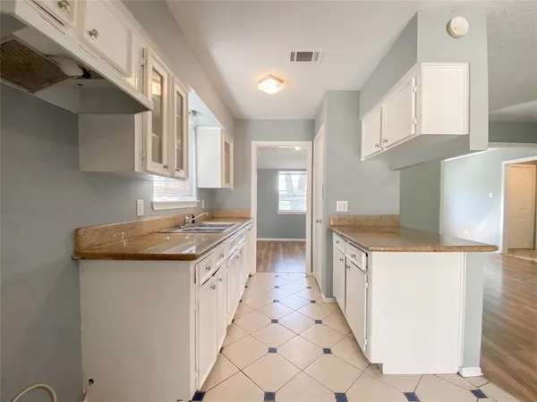 a kitchen with granite countertop a sink and cabinets