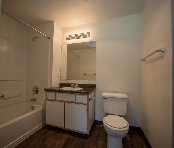 a bathroom with a granite countertop toilet a sink and bathtub