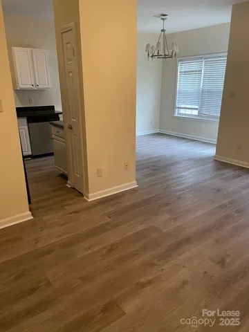 an empty room with wooden floor and cabinet