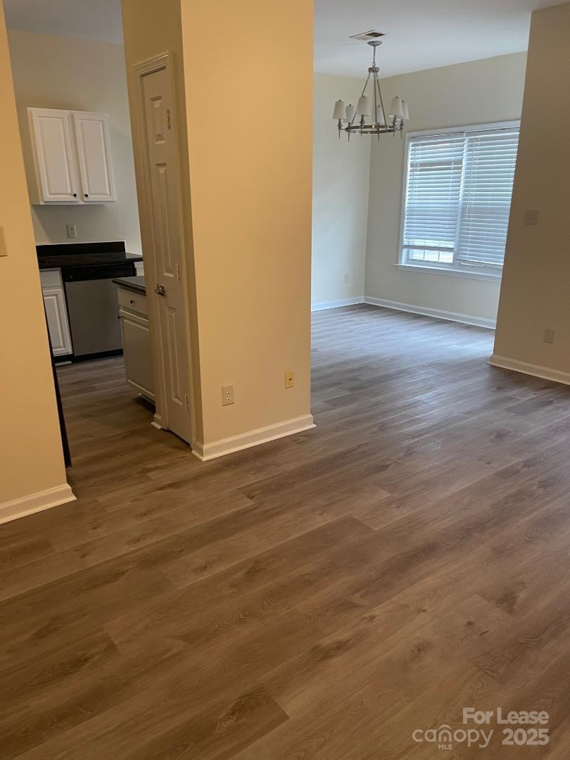 2121 Lennox Square Road Charlotte, NC 28210 - Photo 11 of 17 an empty room with wooden floor and cabinet