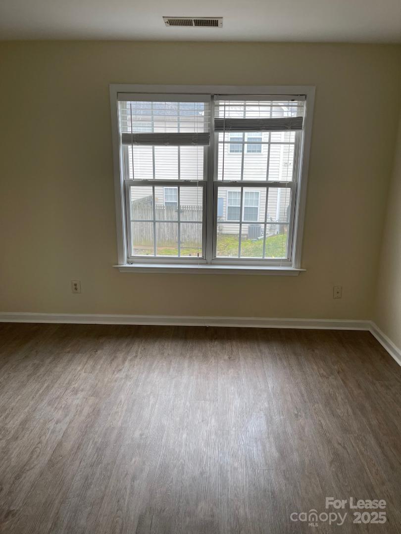 2121 Lennox Square Road Charlotte, NC 28210 - Photo 13 of 17 an empty room with wooden floor and windows