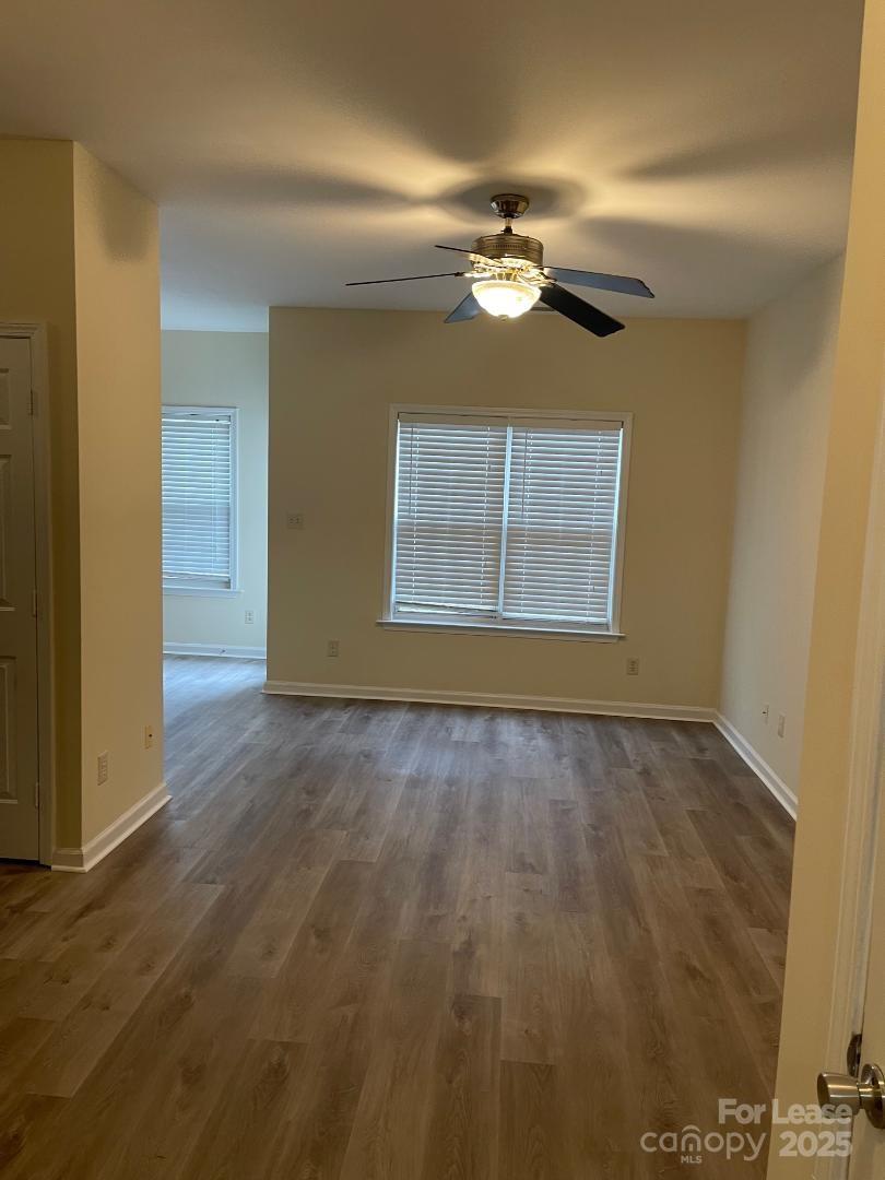 2121 Lennox Square Road Charlotte, NC 28210 - Photo 3 of 17 an empty room with a chandelier fan and windows