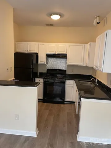a kitchen with stainless steel appliances a stove and white cabinets
