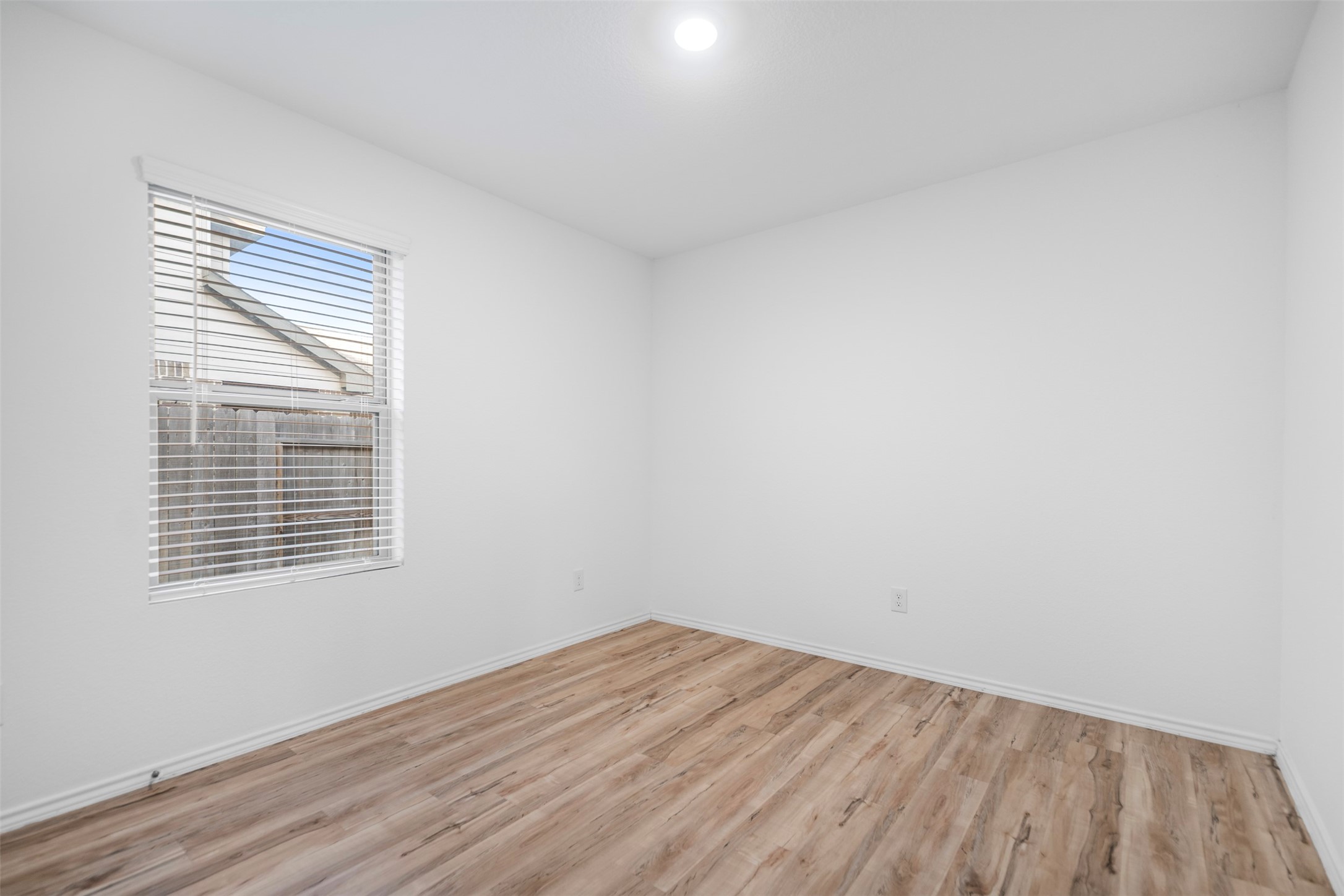 14519 Broadbury Pond Road Rosharon, TX 77583 - Photo 13 of 22 a view of an empty room with wooden floor and a window