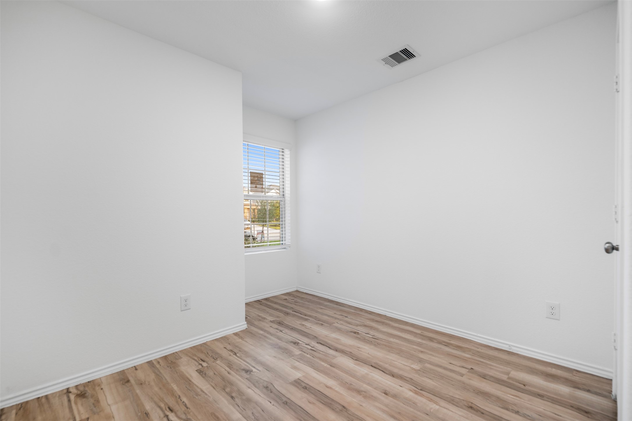 14519 Broadbury Pond Road Rosharon, TX 77583 - Photo 17 of 22 a view of an empty room with wooden floor and a window