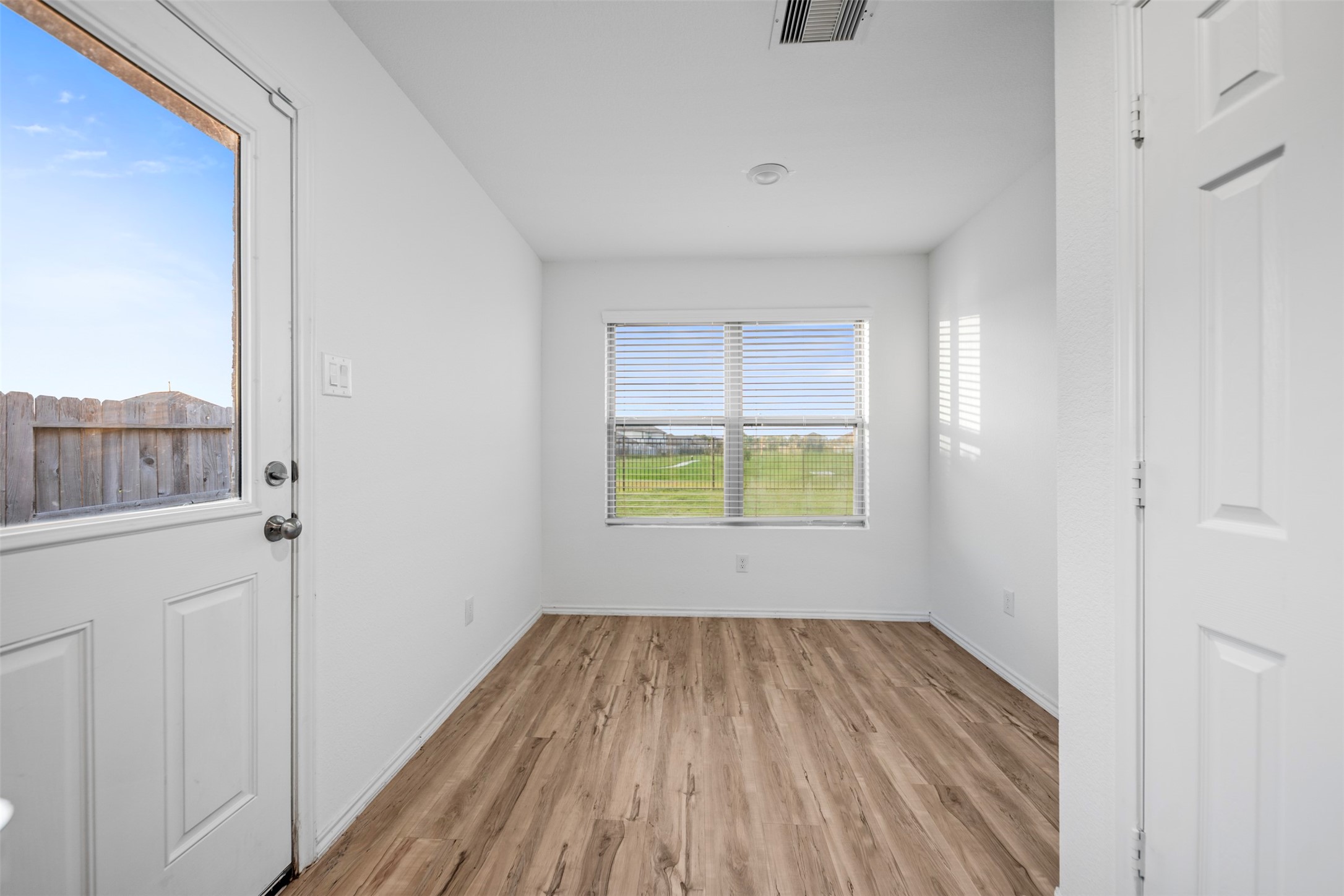 14519 Broadbury Pond Road Rosharon, TX 77583 - Photo 19 of 22 a view of an empty room with wooden floor and a window