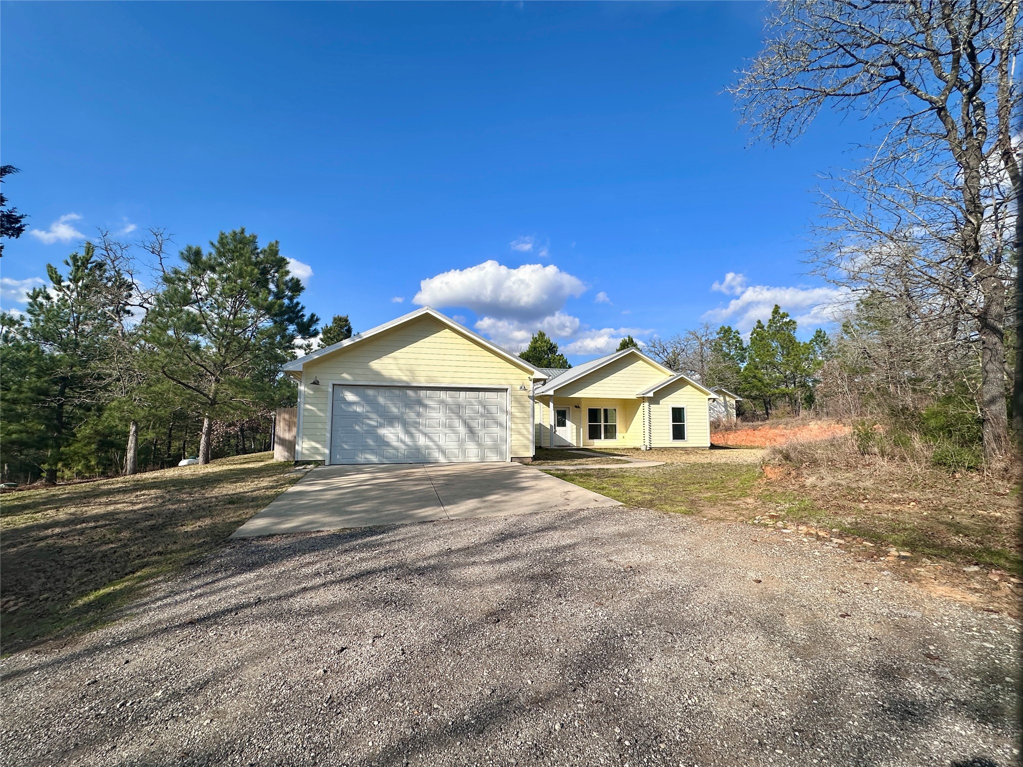 124 Pine Path Bastrop, TX 78602 - Photo 4 of 31 Farmhouse-style home featuring a 2-car garage and concrete driveway