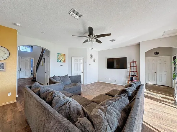 a living room with furniture and a wooden floor