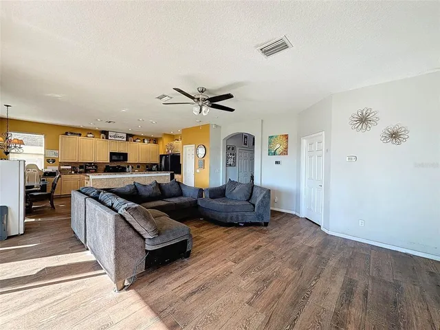 a large kitchen with a stove a refrigerator a sink dishwasher with a dining table and chair