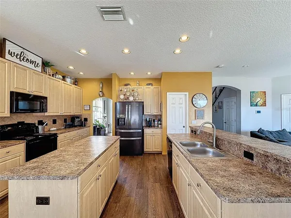 a kitchen with granite countertop a sink a stove and cabinets