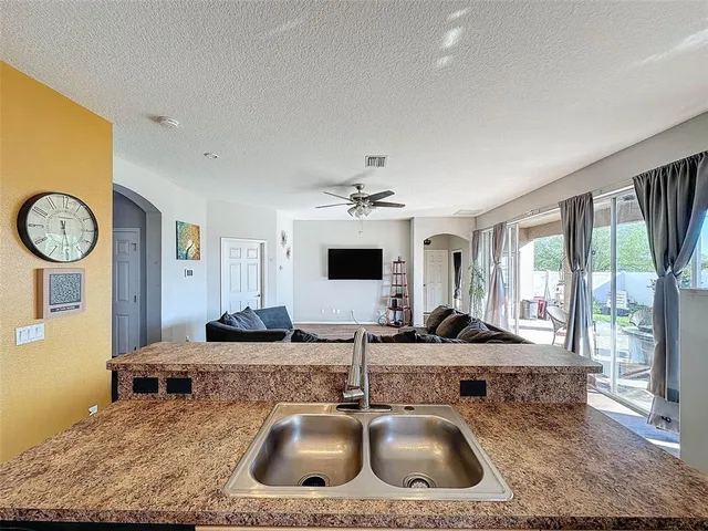 a living room with furniture a flat screen tv and a window
