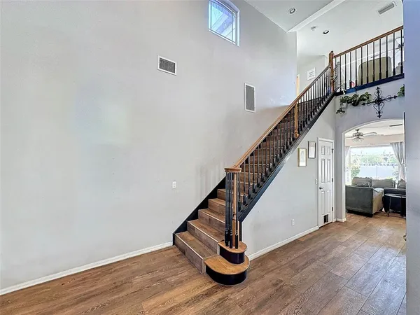a view of a hallway with wooden floor and staircase