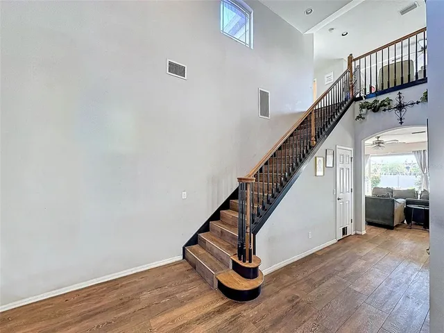 a view of a hallway with wooden floor and staircase