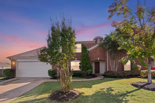 a front view of a house with a yard garage and outdoor seating