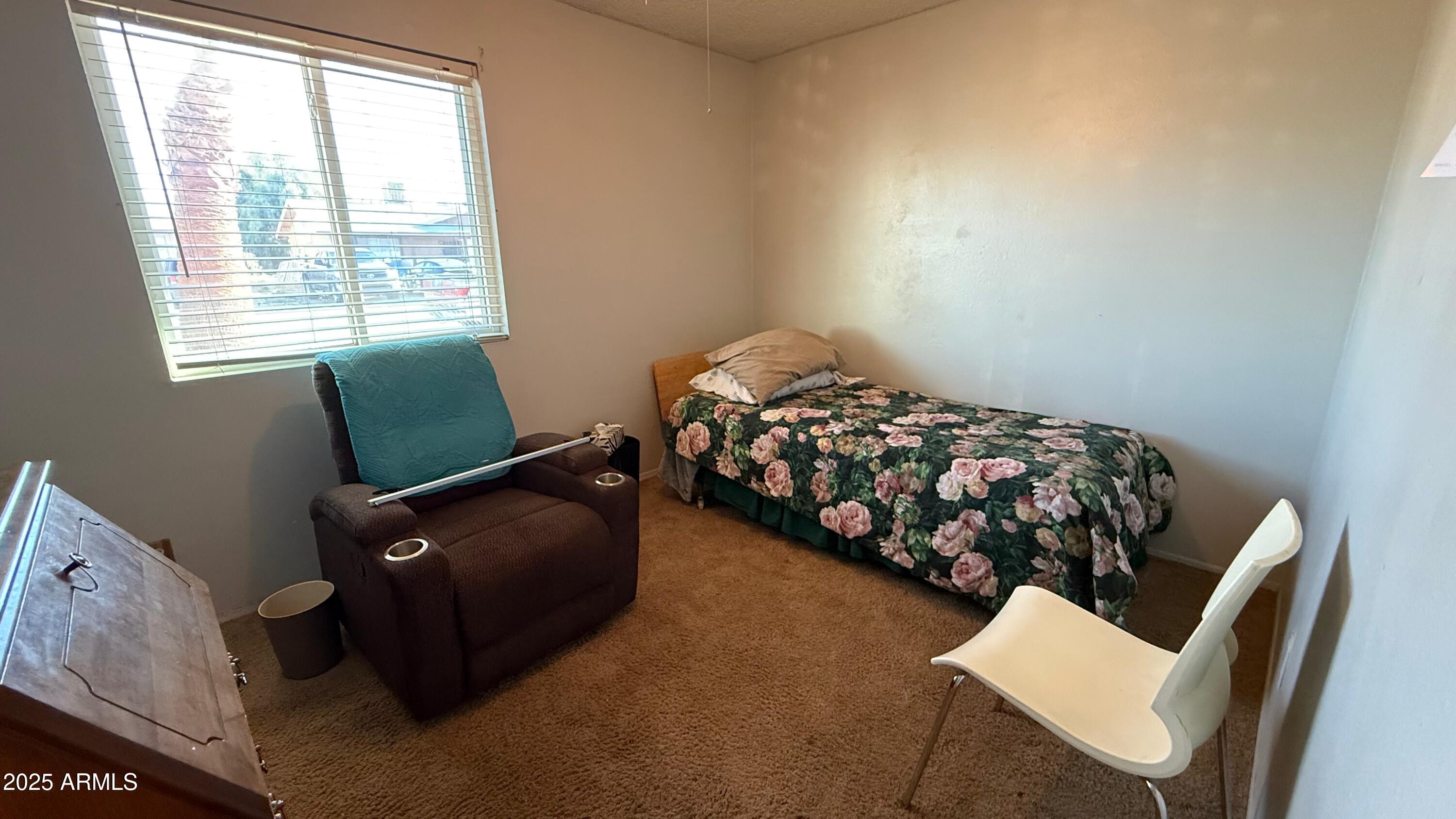 8524 West Weldon Avenue Phoenix, AZ 85037 - Photo 12 of 17 a bedroom with a bed and a chair