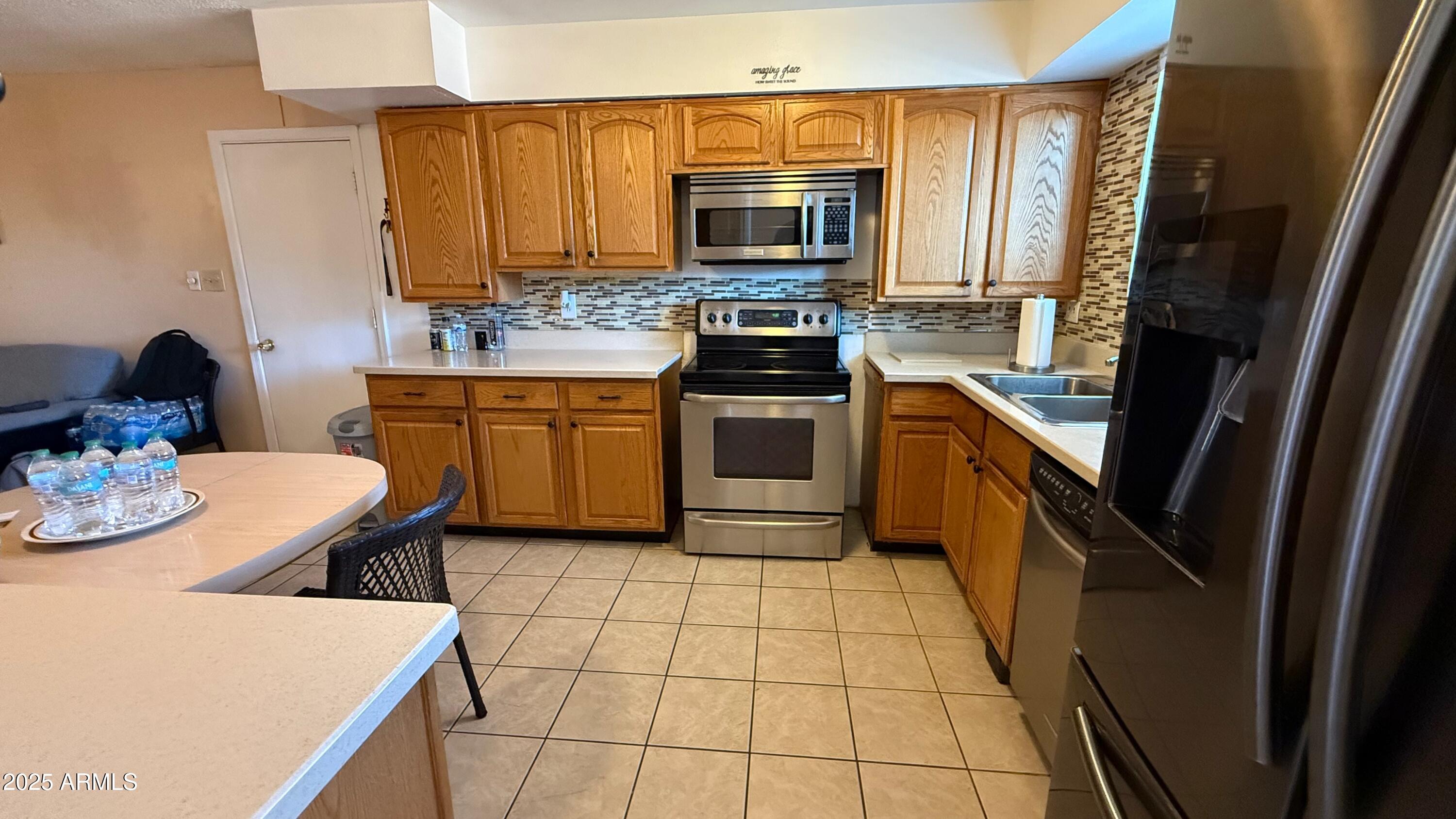 8524 West Weldon Avenue Phoenix, AZ 85037 - Photo 4 of 17 a kitchen with stainless steel appliances a stove microwave and cabinets