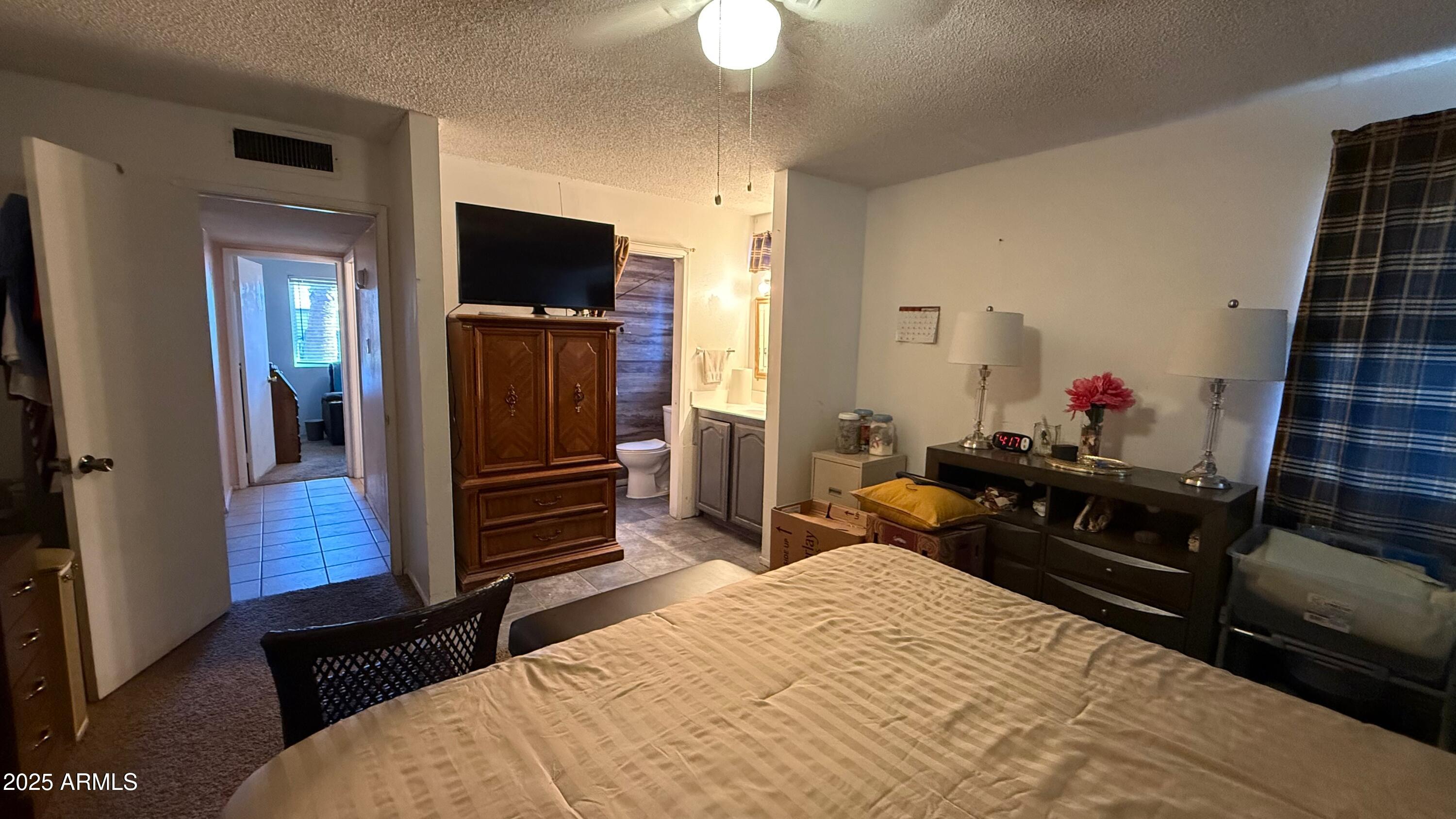 8524 West Weldon Avenue Phoenix, AZ 85037 - Photo 10 of 17 a bedroom with a bed and flat screen tv