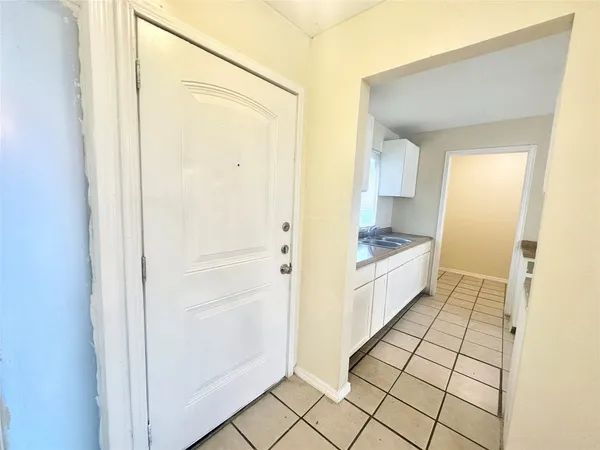 a large white bathroom with a granite countertop sink and a mirror