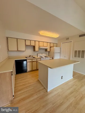 a kitchen with stainless steel appliances a stove a sink and a refrigerator