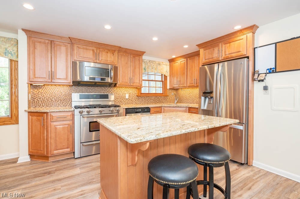 4639 Tippecanoe Road Youngstown, OH 44511 - Photo 2 of 36 Kitchen with light hardwood / wood-style flooring, a kitchen island, stainless steel appliances, and backsplash