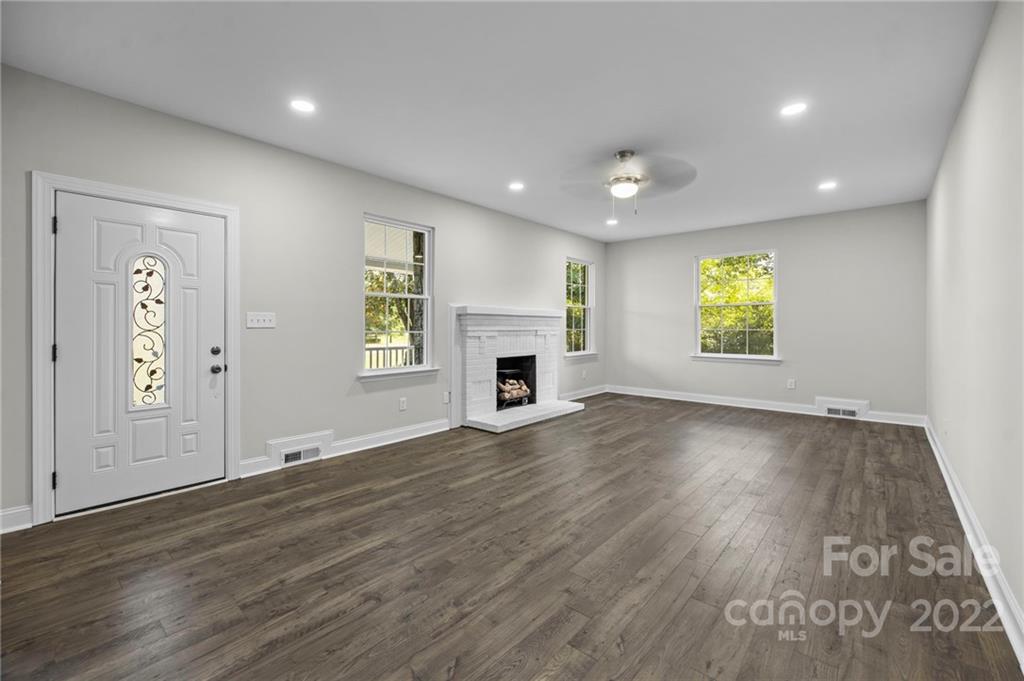 6000 Hickory Grove Road Charlotte, NC 28215 - Photo 22 of 40 an empty room with wooden floor fireplace and windows