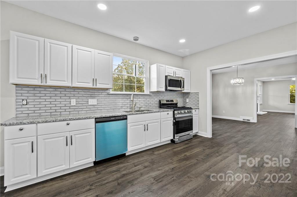 6000 Hickory Grove Road Charlotte, NC 28215 - Photo 27 of 40 a kitchen with granite countertop white cabinets and appliances