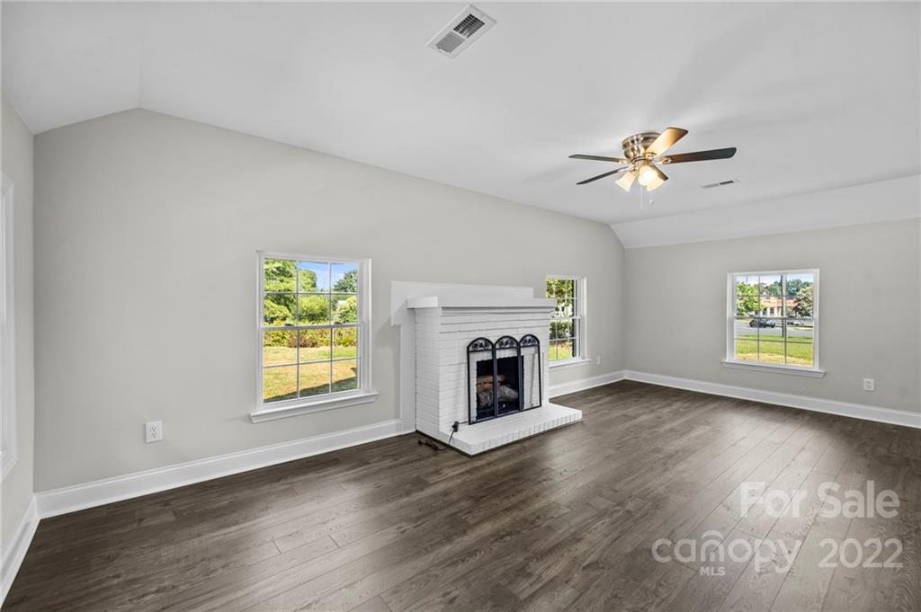 6000 Hickory Grove Road Charlotte, NC 28215 - Photo 30 of 40 an empty room with windows fireplace and a ceiling fan