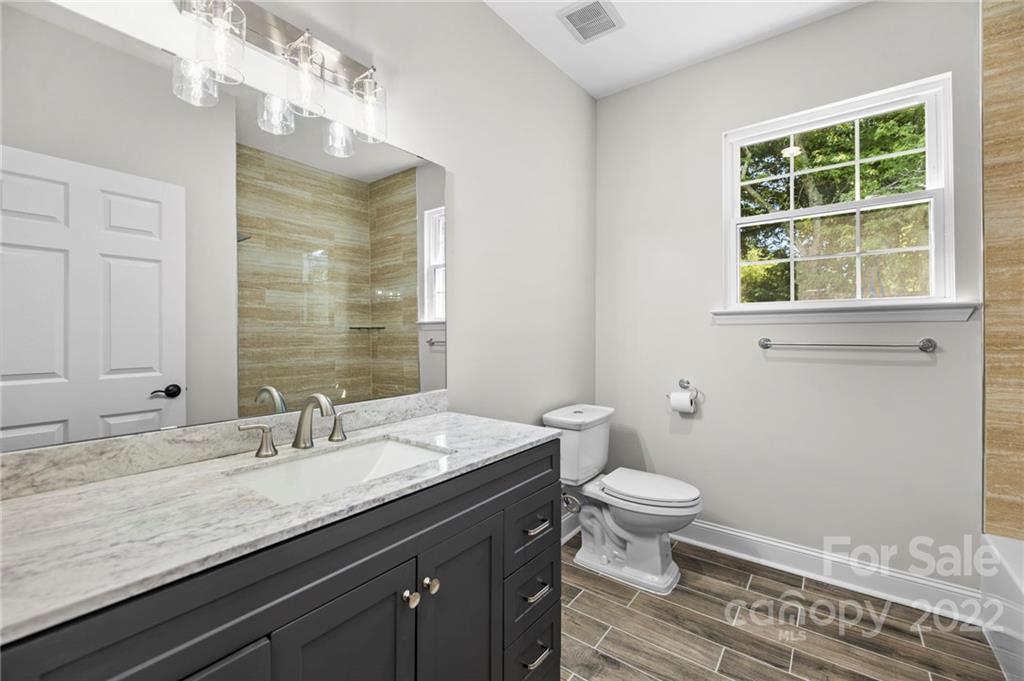 6000 Hickory Grove Road Charlotte, NC 28215 - Photo 33 of 40 a bathroom with a granite countertop toilet a sink and a large mirror