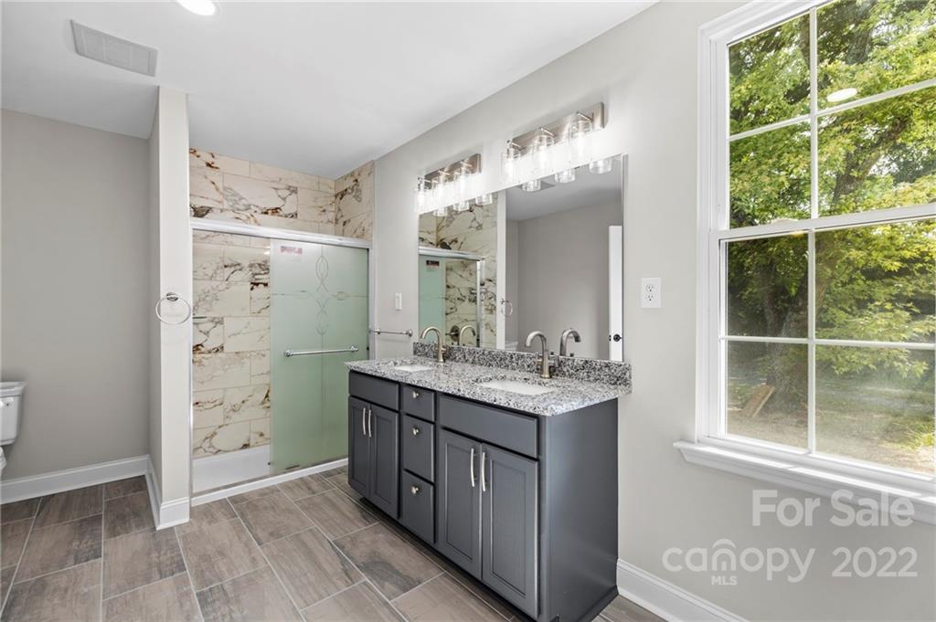6000 Hickory Grove Road Charlotte, NC 28215 - Photo 34 of 40 a bathroom with a granite countertop sink a large mirror and a shower