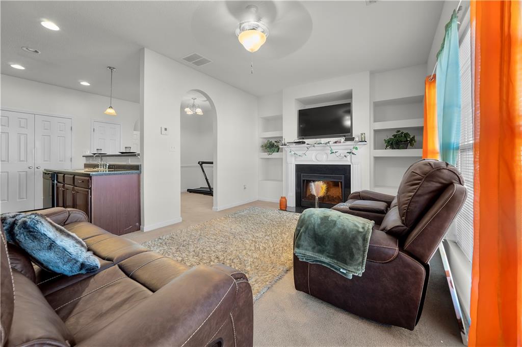 6120 Capitol Knoll Fairburn, GA 30213 - Photo 11 of 28 a living room with furniture a flat screen tv and a fireplace