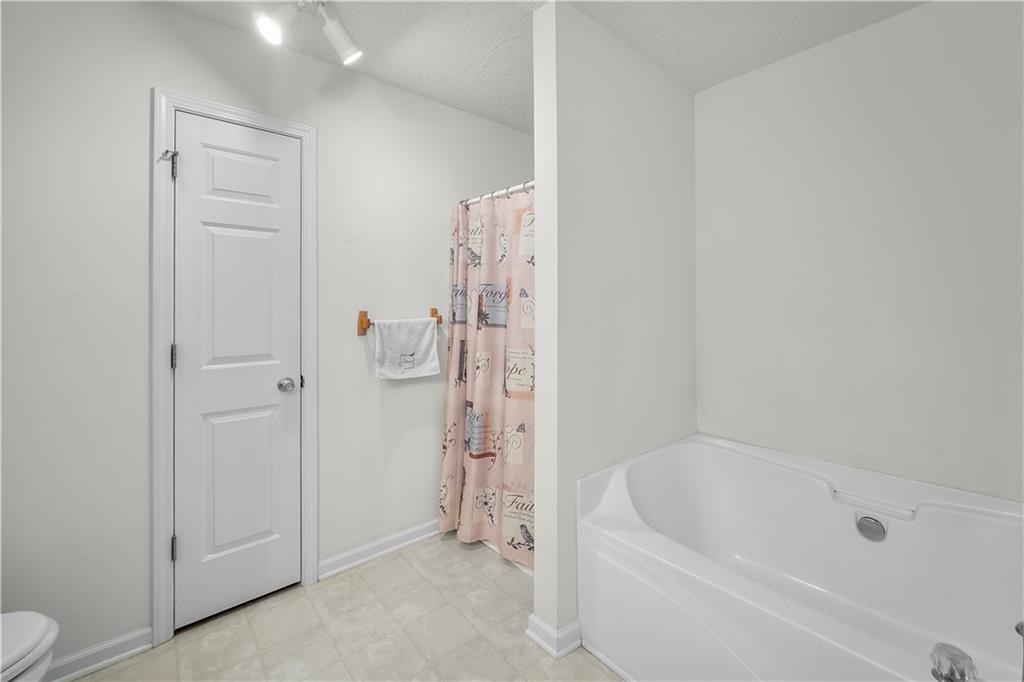 6120 Capitol Knoll Fairburn, GA 30213 - Photo 17 of 28 a bathroom with a bathtub and a shower