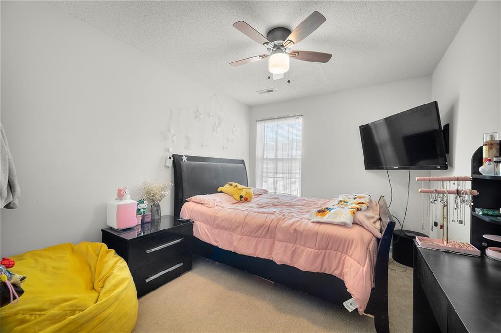6120 Capitol Knoll Fairburn, GA 30213 - Photo 22 of 28 a bedroom with a bed window and a flat screen tv