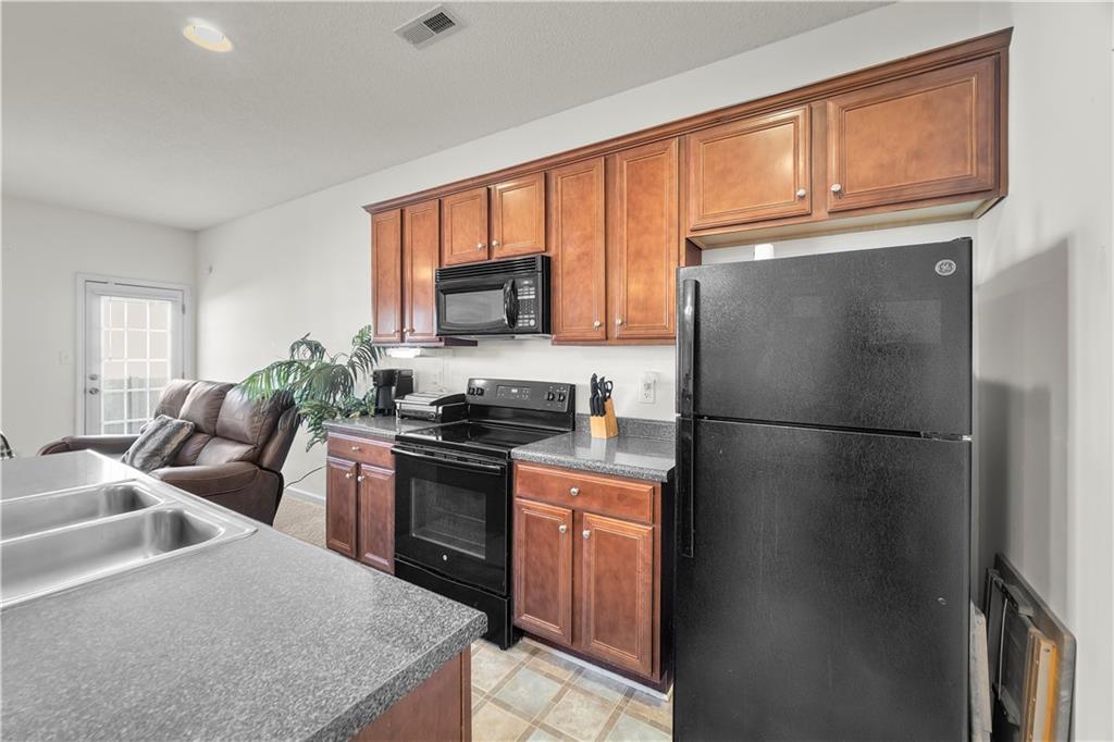 6120 Capitol Knoll Fairburn, GA 30213 - Photo 7 of 28 a kitchen with stainless steel appliances granite countertop a refrigerator stove top oven a sink and dishwasher