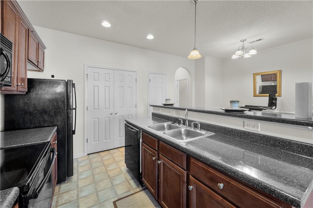6120 Capitol Knoll Fairburn, GA 30213 - Photo 8 of 28 a kitchen with granite countertop a sink stainless steel appliances and cabinets