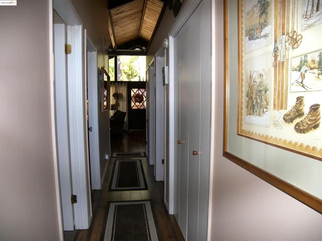 a view of a roof deck with table and chairs under an umbrella with wooden floor