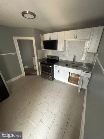 a kitchen with stainless steel appliances a stove a sink and a refrigerator