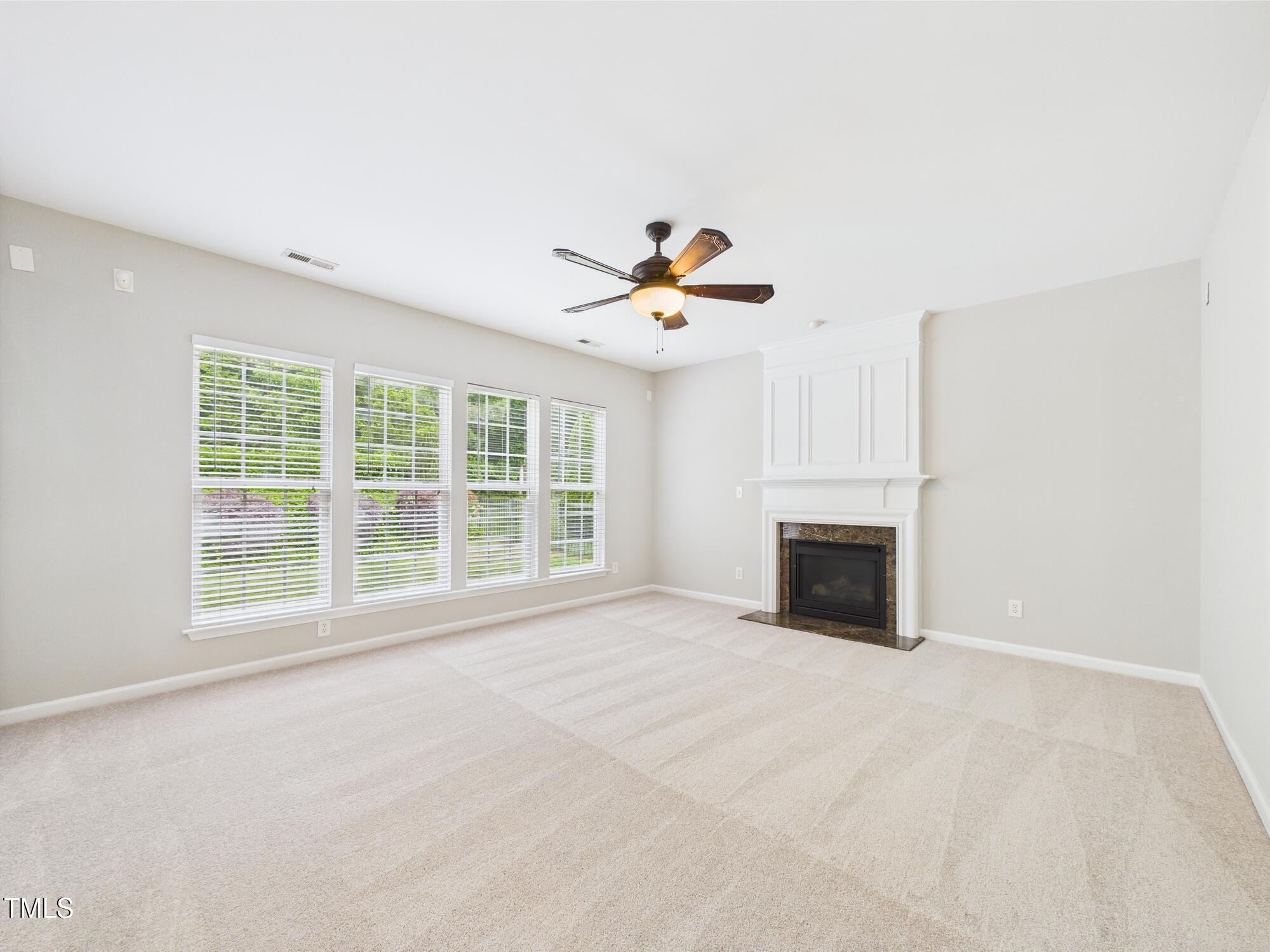 12589 Honeychurch Street Raleigh, NC 27614 - Photo 34 of 100 a view of an empty room with a fireplace and a window