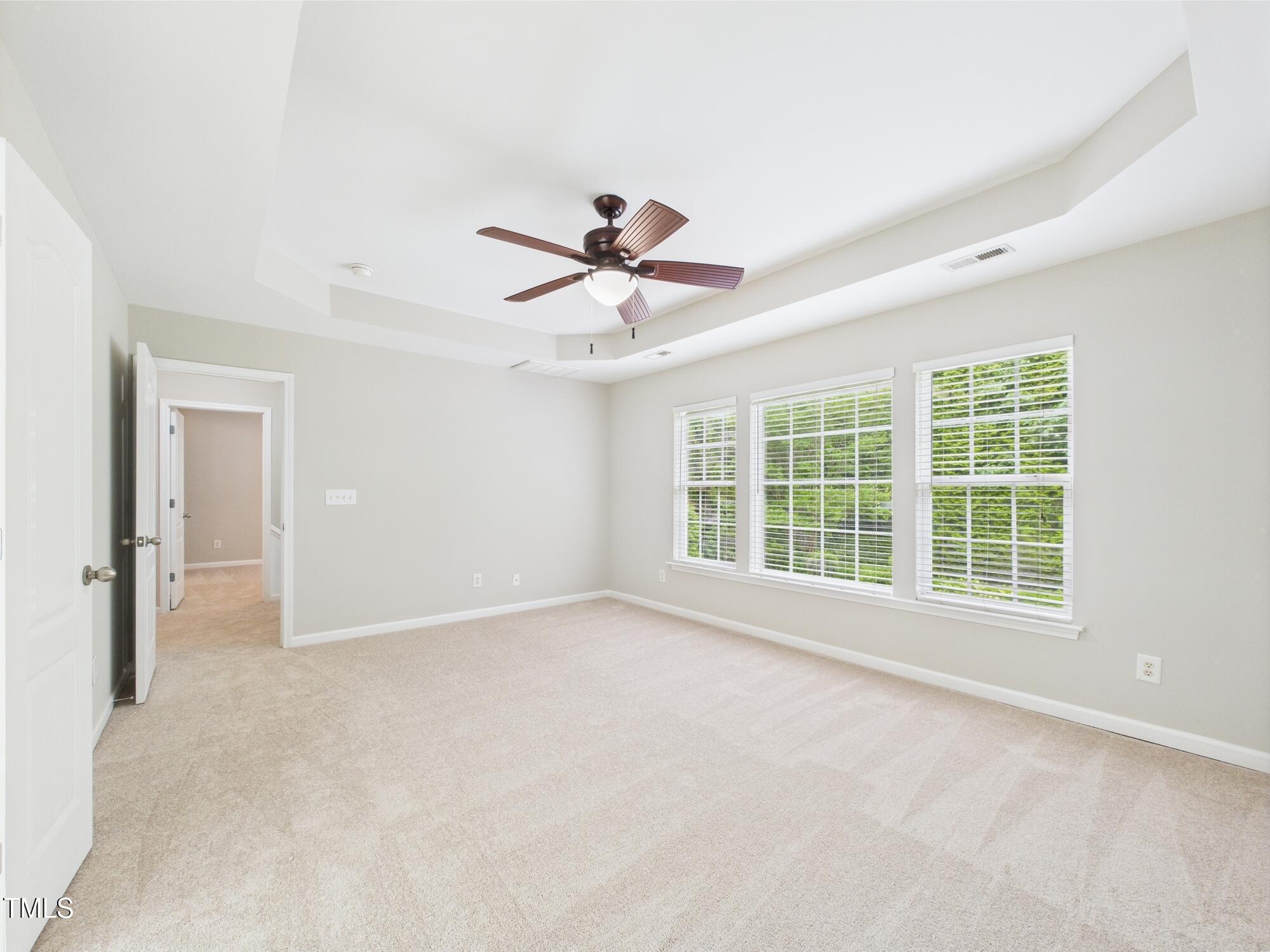 12589 Honeychurch Street Raleigh, NC 27614 - Photo 44 of 100 an empty room with chandelier fan and windows