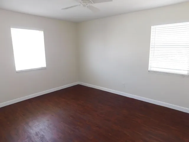 an empty room with wooden floor and a window